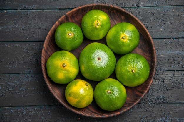 Widok z góry z bliska osiem limonek w misce osiem limonek w misce na środku szarego stołu