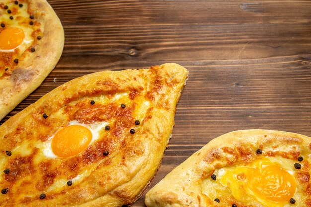 Widok z góry z bliska pieczone pieczywo jajeczne świeże z pieca na brązowym drewnianym biurku ciasto jajko chleb bułka śniadanie