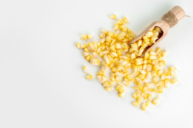 Widok z góry żółte nasiona kukurydzy na białym biurku, kukurydza kolor żywności posiłek