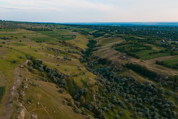 Widok z lotu ptaka na malowniczy krajobraz lądu, drzewa, skały, niebo odbite w wodzie.