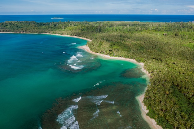 Widok z lotu ptaka na piękną tropikalną plażę z białym piaskiem i turkusową czystą wodą w Indonezji