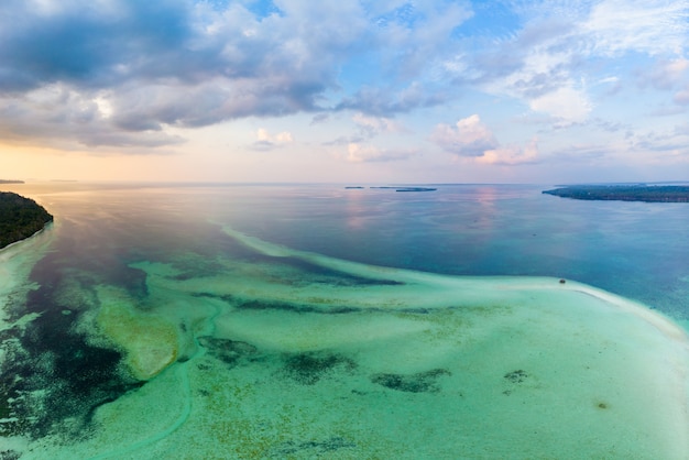 Widok z lotu ptaka wyspy tropikalnej plaży rafy karaibskiej dramatyczny niebo przy zmierzchu wschodem słońca. indonezja archipelag moluków, wyspy kei, morze banda. najlepsze miejsce podróży, nurkowanie z rurką