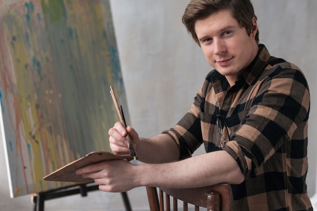 Widok z przodu artsy mężczyzna pozowanie z narzędzi do malowania