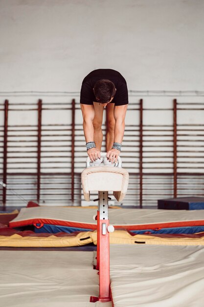 Widok z przodu atletyczny mężczyzna ćwiczy na koniu z łękami