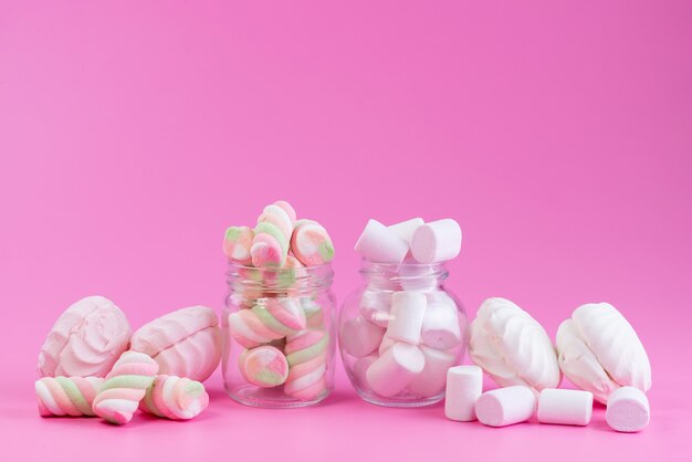 Widok z przodu bezy i pianek marshmallows słodkie i lepkie na różowym, kolorowym słodkim cieście biszkoptowym