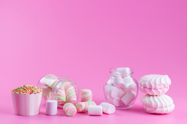 Widok z przodu bezy i pianek marshmallows słodkie i lepkie na różowym, kolorowym słodkim cieście biszkoptowym