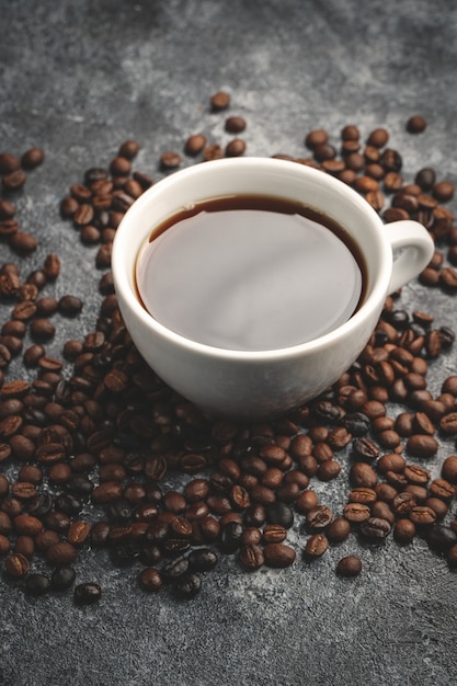 Widok z przodu brązowych nasion kawy z filiżanką kawy na ciemnej ścianie