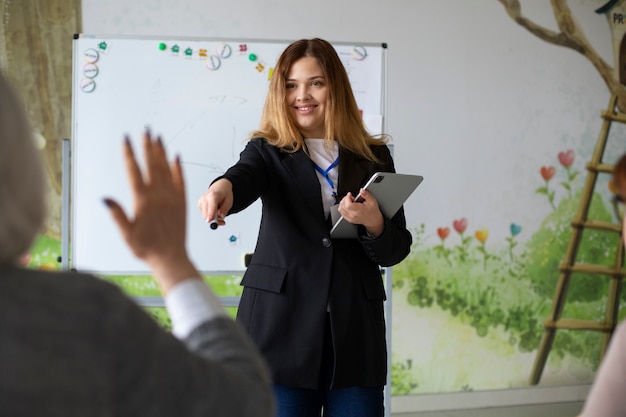 Bezpłatne zdjęcie widok z przodu buźkę nauczyciela trzymając tabletkę