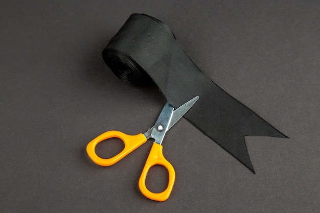 widok z przodu czarna kokarda z nożyczkami na ciemnej powierzchni kolor ciemna dzianina do szycia ubrań