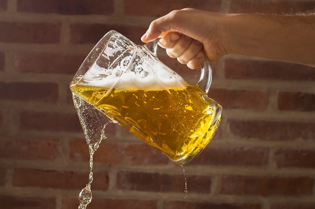 Bezpłatne zdjęcie widok z przodu dłoni z kufel nalewania piwa