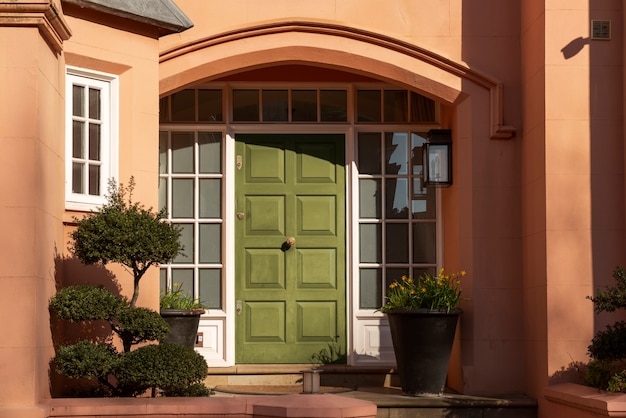 Widok z przodu drzwi wejściowych z pomarańczową ścianą i roślinami