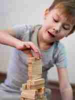 Bezpłatne zdjęcie widok z przodu dziecko bawi się drewnianą wieżą