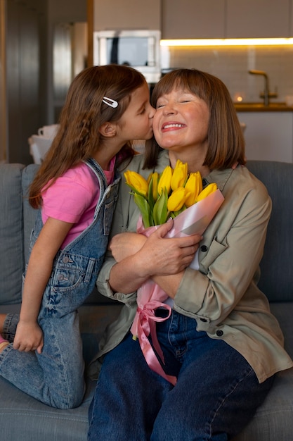 Bezpłatne zdjęcie widok z przodu dziewczyna z babcią i kwiatami