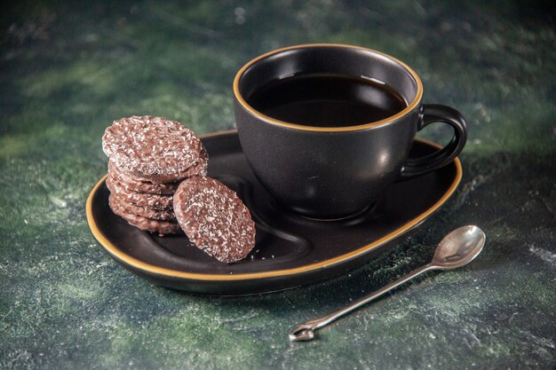 widok z przodu filiżanka herbaty w czarnej filiżance i talerz z herbatnikami na ciemnej powierzchni ceremonii cukru szkło śniadanie deser kolorowy tort
