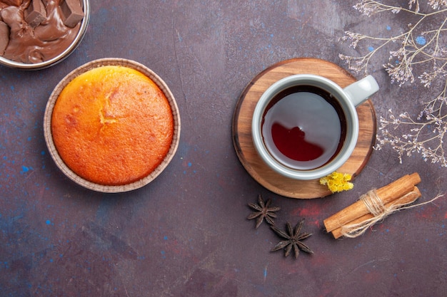 Widok z przodu filiżanka herbaty z cynamonem na ciemnym biurku pić herbatę w słodkim kolorze