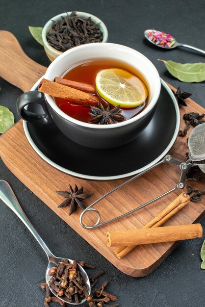 Widok z przodu filiżanka herbaty z cytryną i świeżą czarną herbatą na ciemnym tle ceremonia herbata woda kolor zdjęcie napój