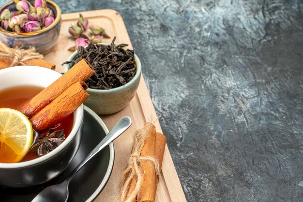 Widok z przodu herbata cytrynowa w filiżance i czajnik na szarym tle kolor poranna owocowa ceremonia śniadaniowa zdjęcie jedzenie wolne miejsce