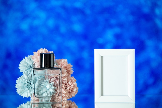 Widok z przodu kobiece perfumy małe białe kwiaty ramki na zdjęcia na niebieskim niewyraźnym tle z wolną przestrzenią
