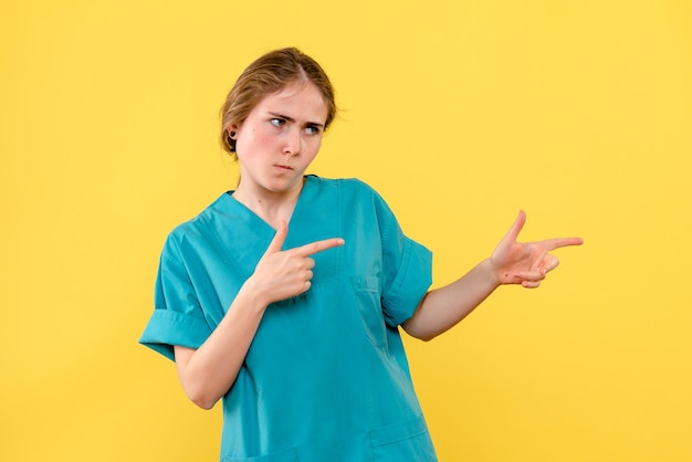 Widok z przodu kobieta lekarz na żółtym tle emocje zdrowotne szpitala