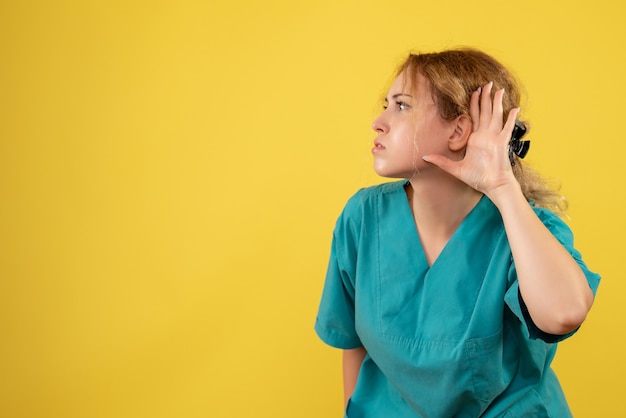 Widok z przodu kobieta lekarz w koszuli medycznej, pielęgniarka szpitalna covid-19 kolory zdrowotne