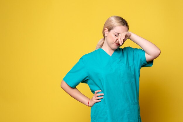 Widok z przodu kobieta lekarz w koszuli medycznej zmęczona, pielęgniarka medyczna emocji covid-19