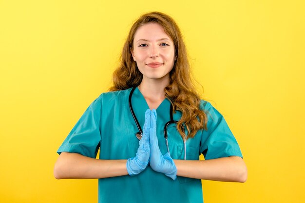 Widok z przodu kobieta lekarz z rękawiczkami na żółtej przestrzeni