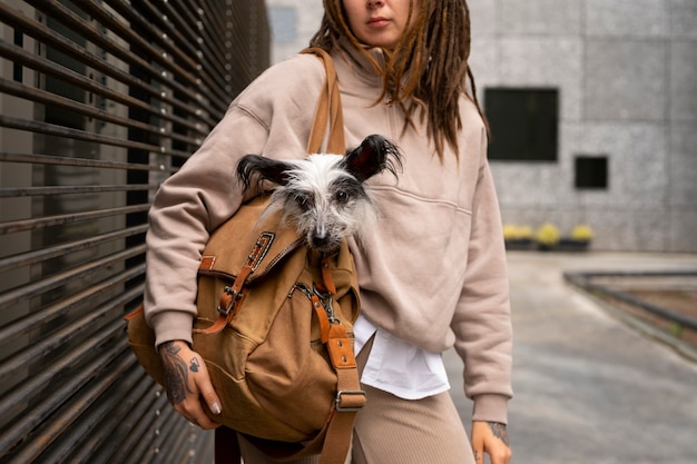 Bezpłatne zdjęcie widok z przodu kobieta niosąca szczeniaka w torbie