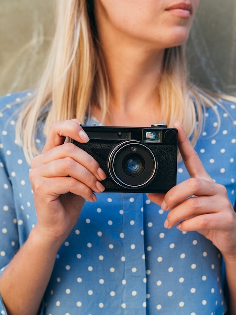 Bezpłatne zdjęcie widok z przodu kobieta trzyma aparat fotograficzny retro