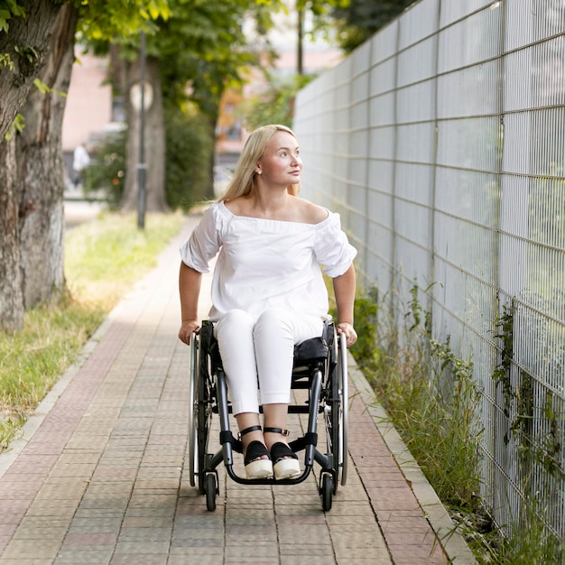 Widok z przodu kobiety na wózku inwalidzkim na zewnątrz