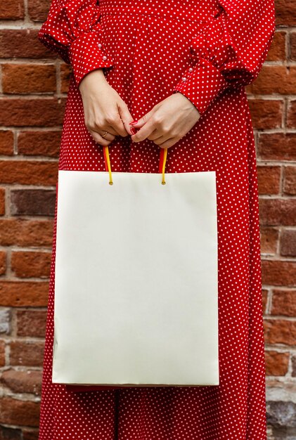 Widok z przodu kobiety pozuje na zewnątrz z torbą na zakupy