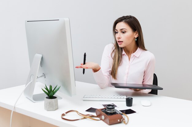 Widok z przodu kobiety pracującej, patrząc na komputer i nie rozumiejąc, co się dzieje
