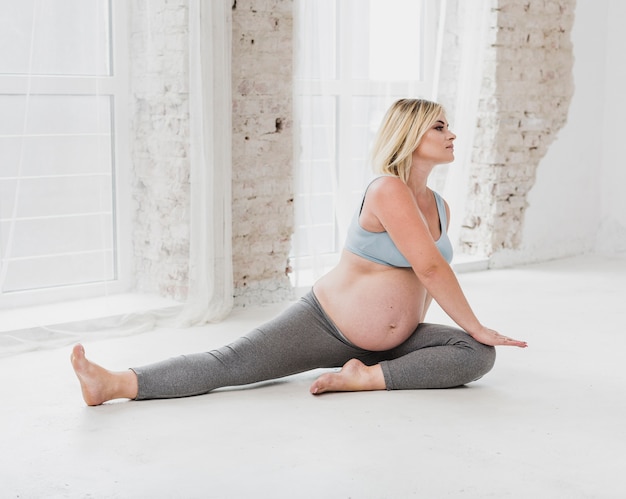Bezpłatne zdjęcie widok z przodu kobiety w ciąży ćwiczenia