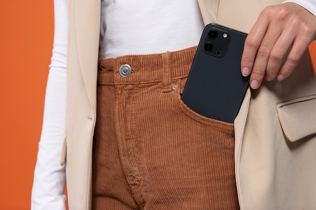 Widok z przodu kobiety wkładającej lub wyciągającej smartfon z kieszeni