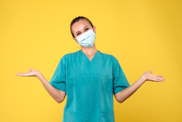 Widok z przodu lekarka w koszuli medycznej i masce ze śmiechem, pandemia wirusa Covid-19 w szpitalu pielęgniarki zdrowia