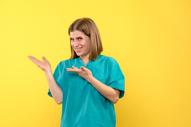 Widok z przodu lekarz kobieta uśmiecha się na żółtej przestrzeni