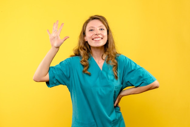 Widok z przodu lekarz kobieta uśmiecha się na żółtej przestrzeni