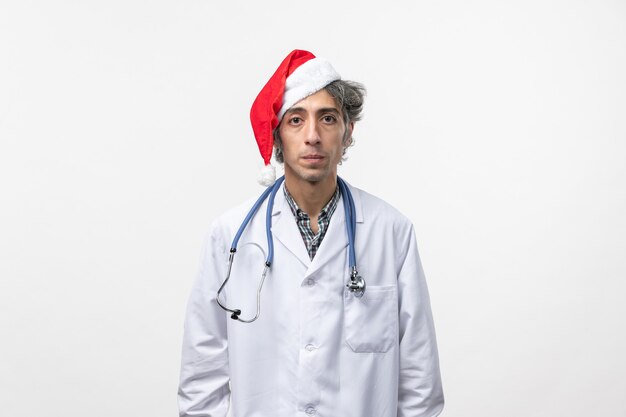 Widok z przodu lekarz mężczyzna w czerwonej czapce na białej ścianie szpital wakacje nowego roku