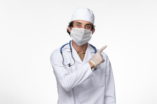 Widok z przodu lekarza płci męskiej w kombinezonie medycznym i noszącym maskę jako ochrona przed zakażeniem wirusem choroby białej ściany - pandemia