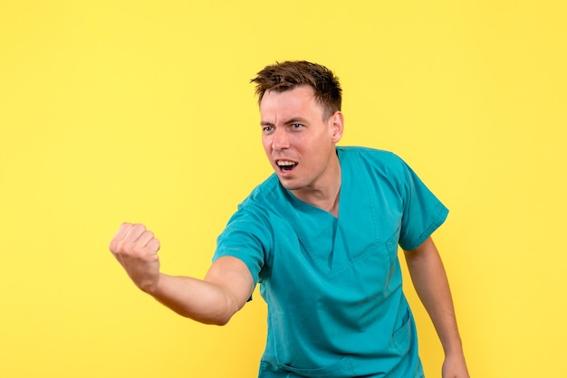 Bezpłatne zdjęcie widok z przodu lekarza płci męskiej z wyrazem radości na żółtej ścianie