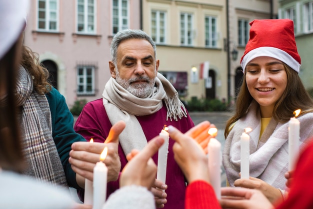 Bezpłatne zdjęcie widok z przodu ludzi trzymających świece