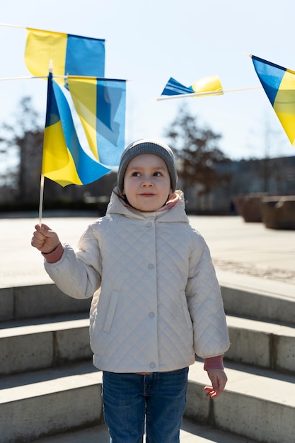 Bezpłatne zdjęcie widok z przodu małe dziecko trzymające ukraińską flagę