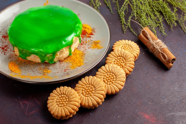 Bezpłatne zdjęcie widok z przodu małe pyszne ciasto z zielonym kremem i ciasteczkami na ciemnej powierzchni ciastko biszkoptowe słodkie ciasto cukrowe