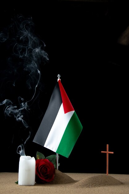 Widok z przodu małego grobu z palestyńską flagą na czarno