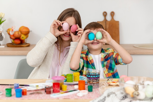 Widok z przodu mama i syn z malowanymi jajkami