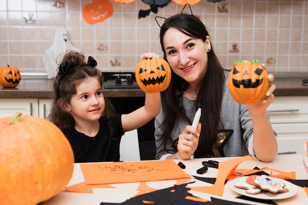 Widok z przodu matki i córki, patrząc na kamery