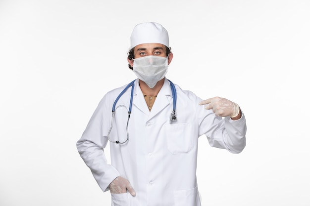 Widok Z Przodu Męski Lekarz W Kombinezonie Medycznym Noszący Sterylną Maskę Jako Ochrona Przed Covid Na Białej ścianie Wirus Pandemii Koronawirusa Zdrowie