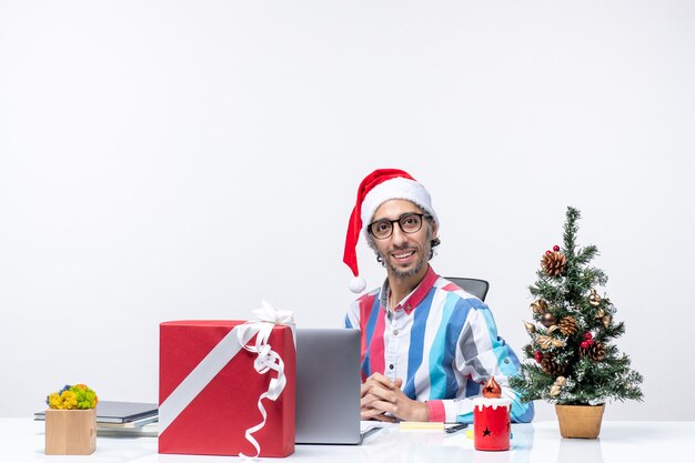 Widok z przodu męski pracownik w swoim miejscu pracy z laptopem i plikami świąteczna wakacyjna praca biurowa