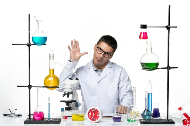 Widok z przodu mężczyzna chemik w białym kombinezonie medycznym machający do kogoś na białym tle Laboratorium wirusów