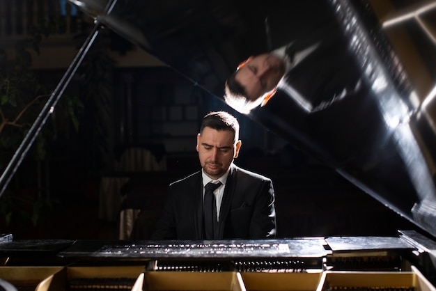 Bezpłatne zdjęcie widok z przodu mężczyzna grający na pianinie