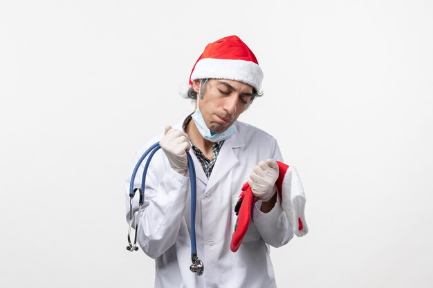 Widok z przodu mężczyzna lekarz czuje się zmęczony na białej ścianie wirus covid wakacje zdrowie